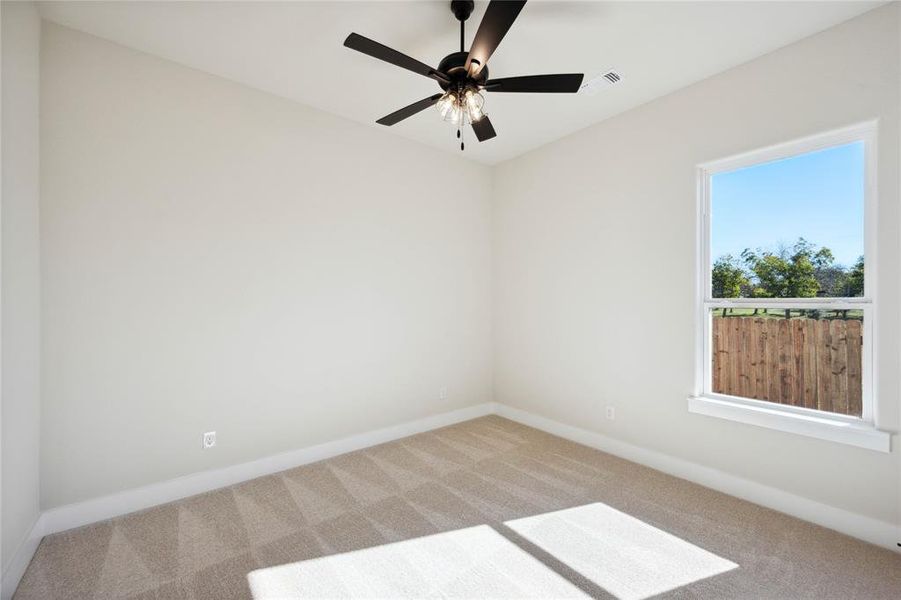 Carpeted spare room featuring ceiling fan