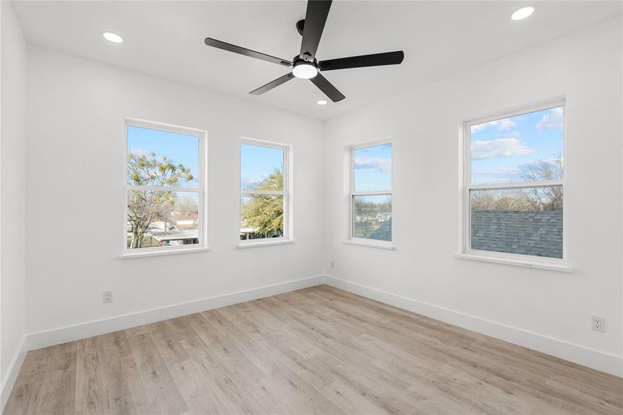 Unfurnished room featuring light wood-style flooring, ceiling fan, healthy amount of natural light, and recessed lighting Unfurnished room featuring light wood-style flooring, ceiling fan, healthy amount of natural light, and recessed lighting