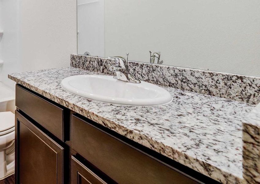 Medina guest bathroom with black and white granite vanity, dark vinyl woodlike floors, and white fixtures