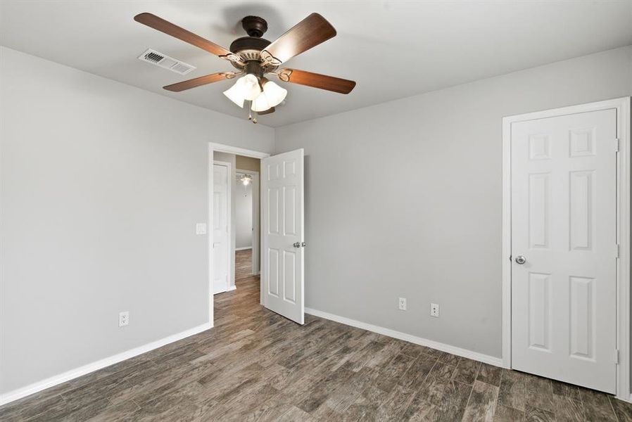 Unfurnished bedroom featuring dark wood-style floors and ceiling fan Unfurnished bedroom featuring dark wood-style floors and ceiling fan
