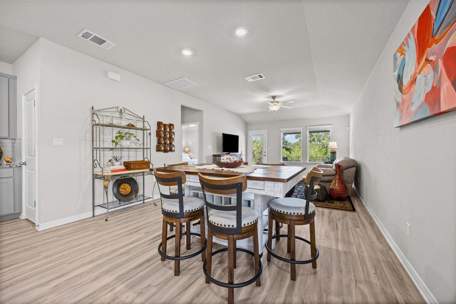 Recessed lighting and warm wood-look flooring enhance the open layout of this inviting living space.
