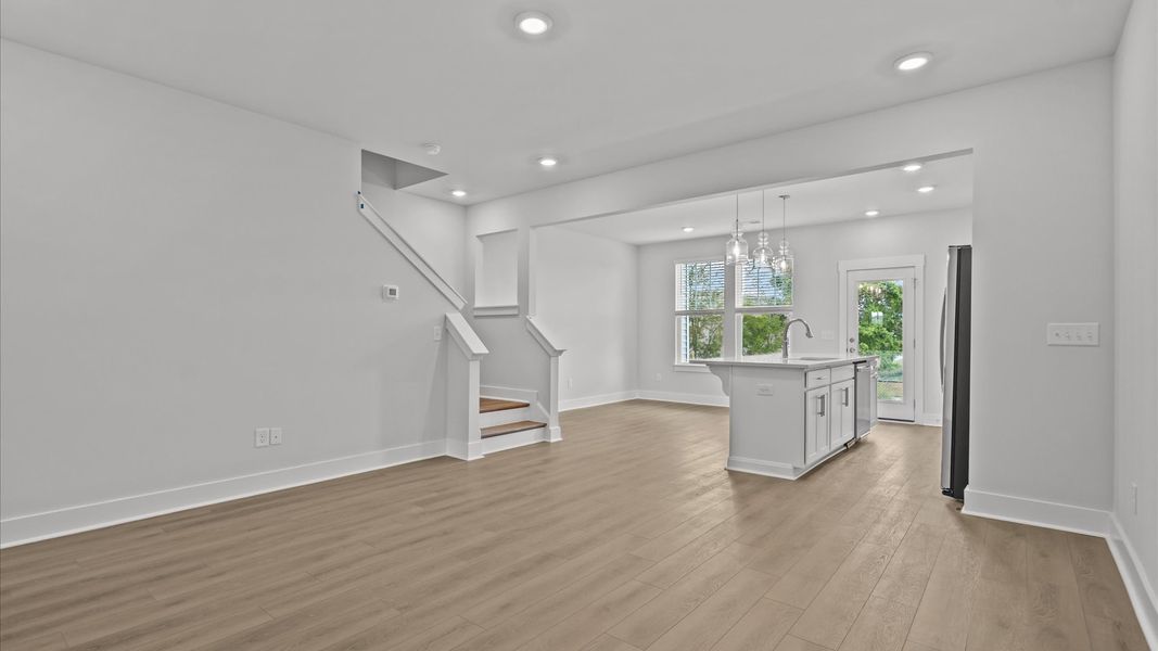 Elegant family room featuring hardwood flooring, large windows, and thoughtful architectural detail