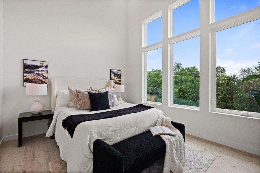 This room features expansive windows, offering abundant natural light and views of the surrounding trees