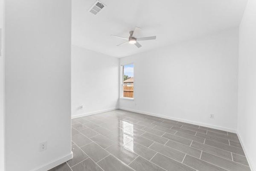 Spare room with ceiling fan and tile patterned floors Spare room with ceiling fan and tile patterned floors