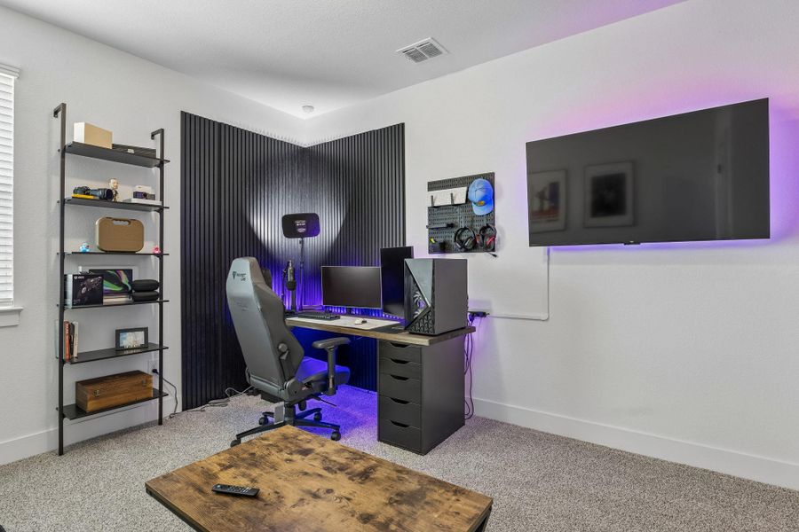 Plush carpeting and modern wall paneling define this versatile home workspace.