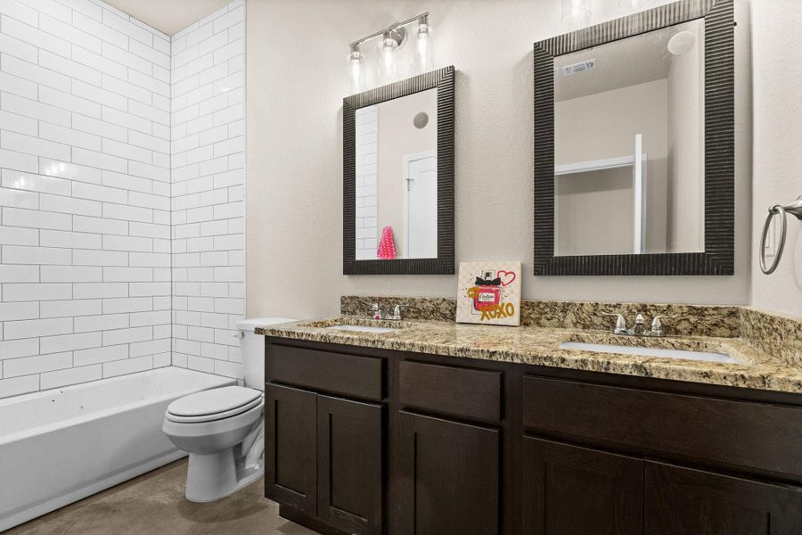 Bathroom featuring double vanity and bathtub / shower combination