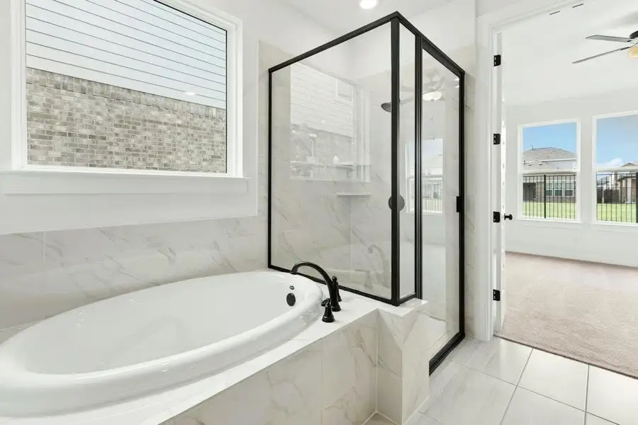 Full bathroom featuring a marble finish shower, tile patterned floors, a bath, carpet floors, and ceiling fan