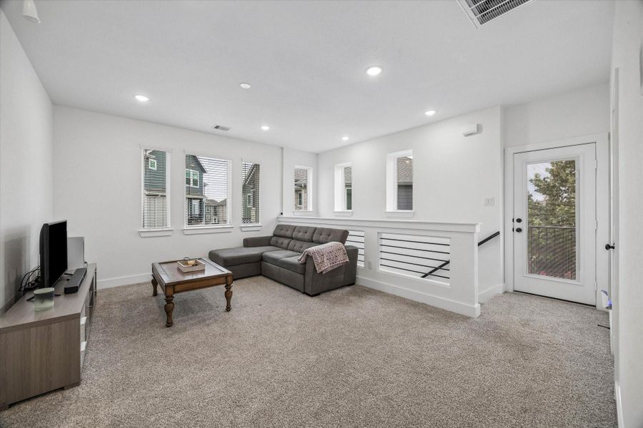 Upstairs, plush carpeting, high ceilings, and transom windows welcome you to the second-floor landing and spacious game room, with access to the patio and a convenient storage closet.