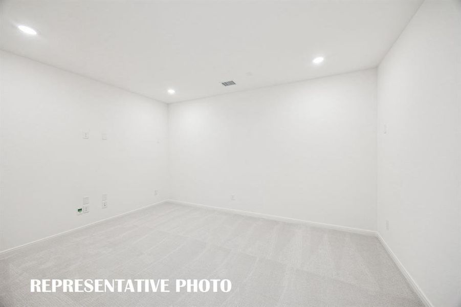 This spacious media room with adjacent game room create the ultimate entertainment zone!  REPRESENTATIVE PHOTO