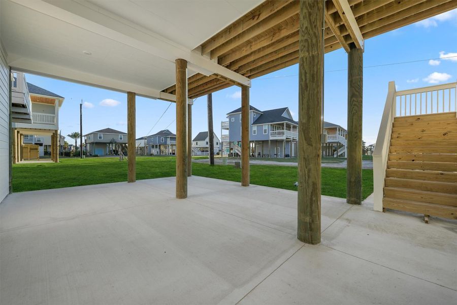 Large covered concrete area beneath the home providing parking and additional outdoor living potential. Large covered concrete area beneath the home providing parking and additional outdoor living potential.