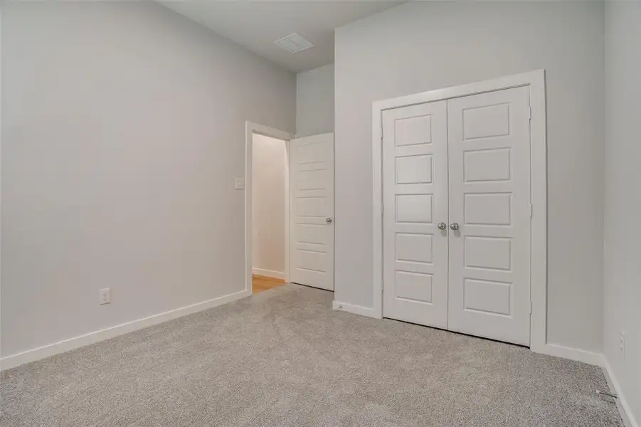 Unfurnished bedroom featuring light carpet and a closet