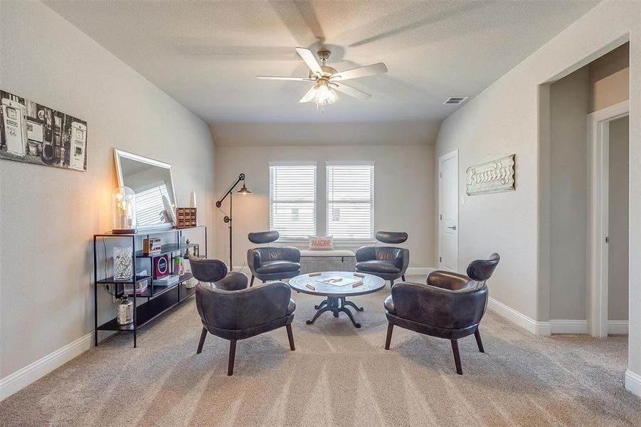 Living room with ceiling fan and light colored carpet