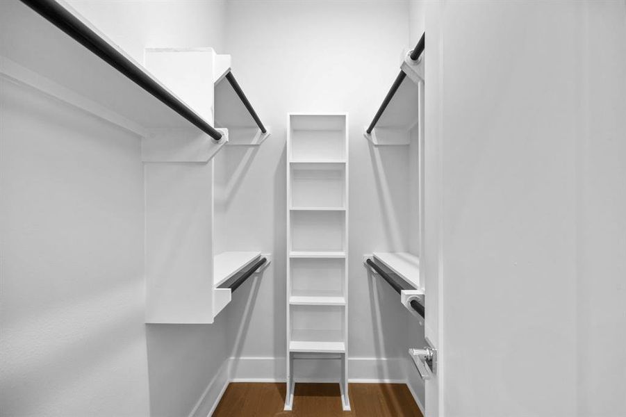 Spacious walk-in closet featuring built-in shelving and ample hanging space for organized storage.