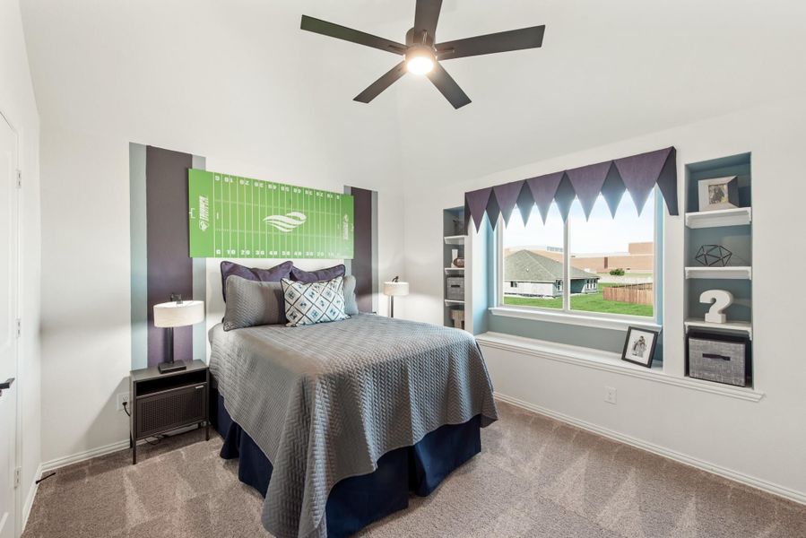 Kids bedroom with football-themed headboard, built-in shelves, ceiling fan, and window seat