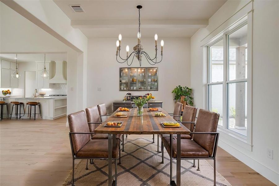 Dining room with light wood-type flooring, a chandelier, and baseboards Dining room with light wood-type flooring, a chandelier, and baseboards