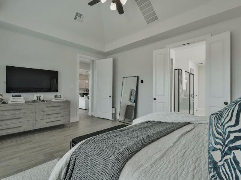 Bedroom featuring light wood-style flooring, a ceiling fan, connected bathroom, and high vaulted ceiling Bedroom featuring light wood-style flooring, a ceiling fan, connected bathroom, and high vaulted ceiling