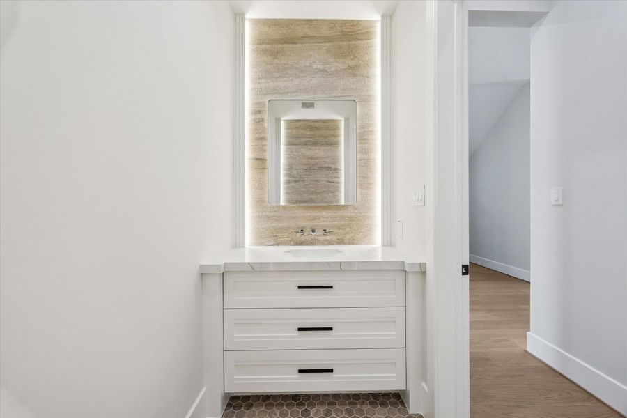 The sophisticated half bath is defined by a lighted vanity delivering a sleek, modern look while maximizing functionality. The sophisticated half bath is defined by a lighted vanity delivering a sleek, modern look while maximizing functionality.