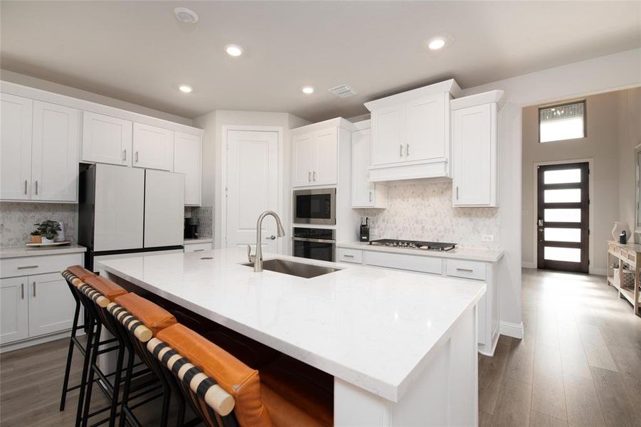 The expansive quartz island provides abundant prep space, casual seating, and a natural gathering spot for family and friends. The expansive quartz island provides abundant prep space, casual seating, and a natural gathering spot for family and friends.