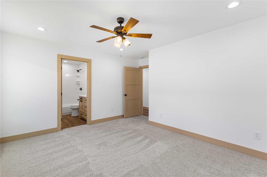 Unfurnished bedroom with recessed lighting, carpet flooring, ensuite bathroom, and a ceiling fan