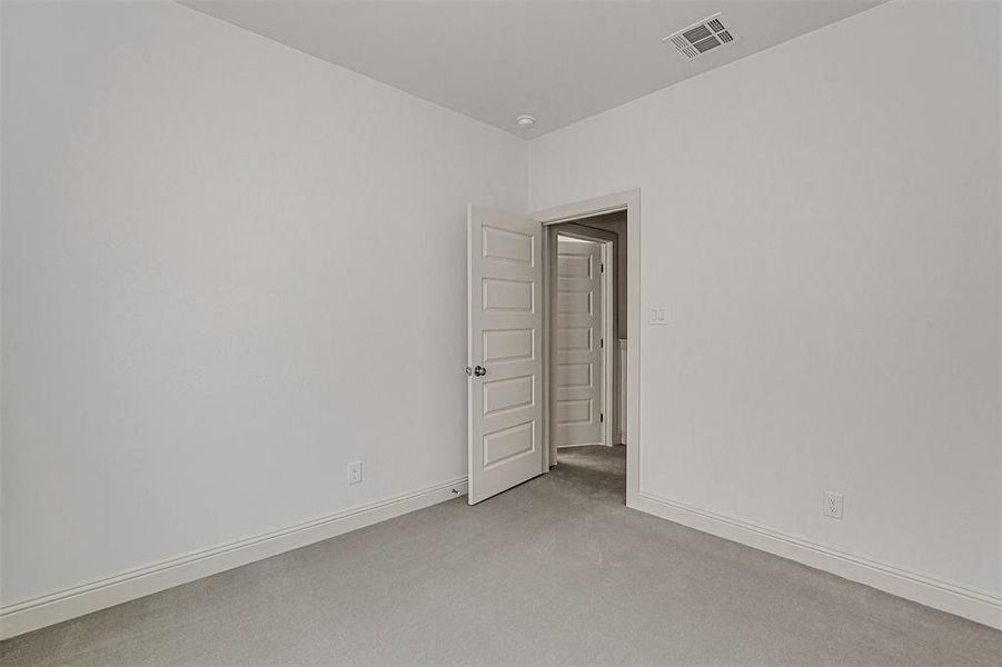Spare room featuring light colored carpet and baseboards