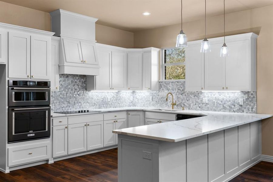 Kitchen featuring light stone counters, sink, decorative light fixtures, and white cabinets