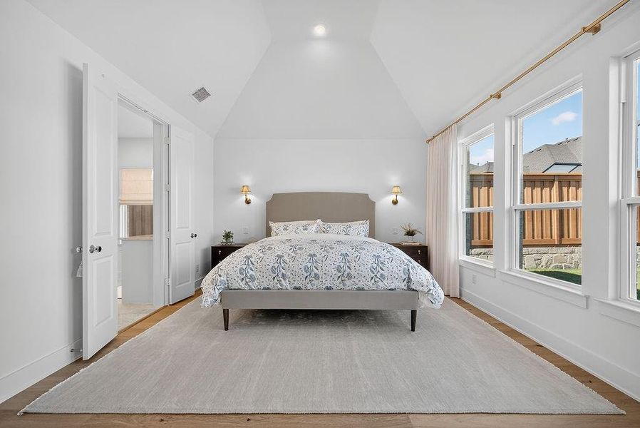 Bedroom featuring wood finished floors and vaulted ceiling Bedroom featuring wood finished floors and vaulted ceiling