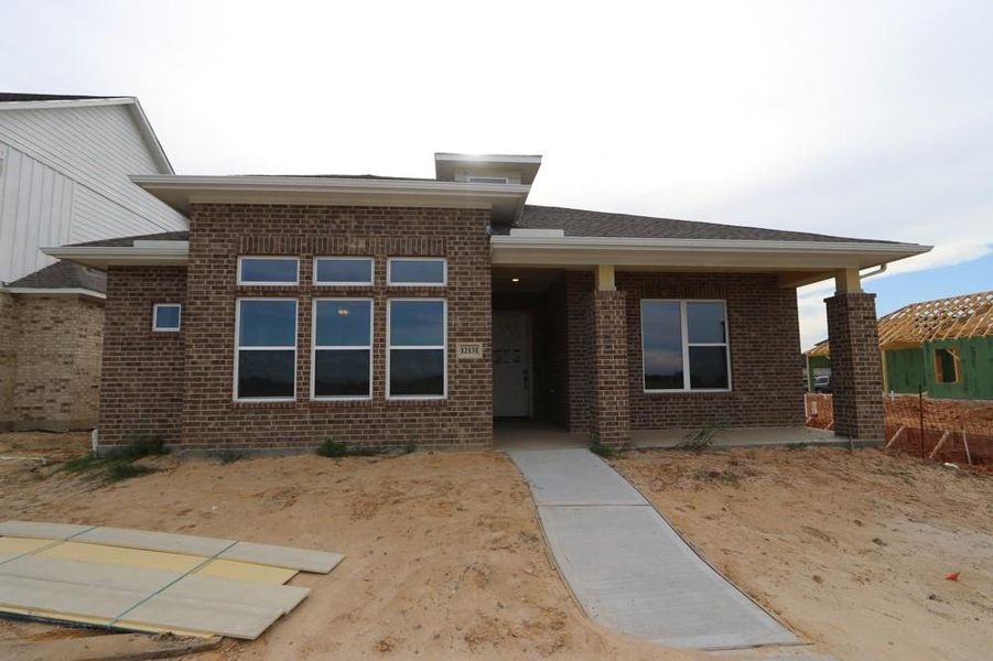 Front exterior of a new home in Riceland 50’ Alley Load Homesites, Mont Belvieu, TX, highlighting curb appeal (Image 2).