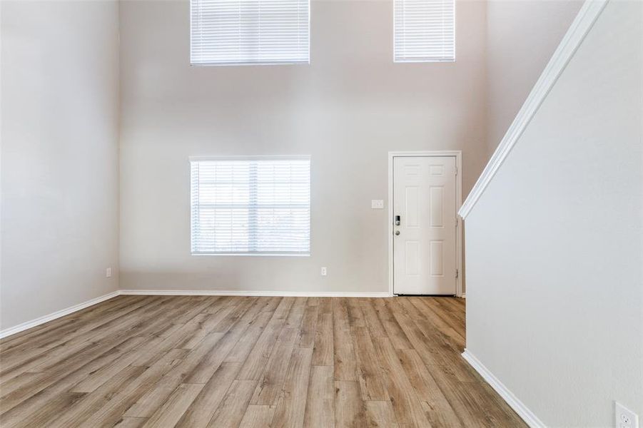 Entrance foyer featuring a towering ceiling and light hardwood / wood-style floors