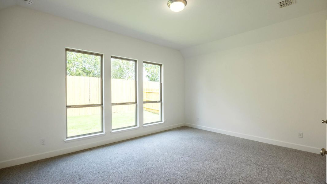 Carpeted spare room with lofted ceiling and baseboards
