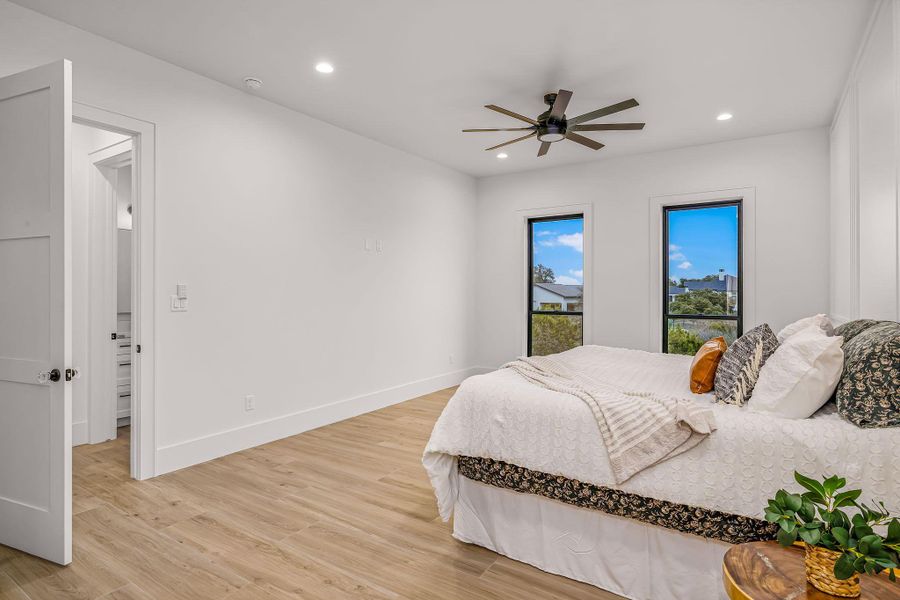 Bedroom featuring light wood-type flooring, ceiling fan, baseboards, and recessed lighting