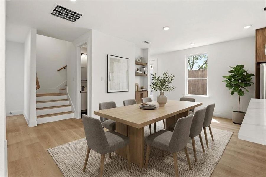 This dining area features light wood flooring and a neutral color palette