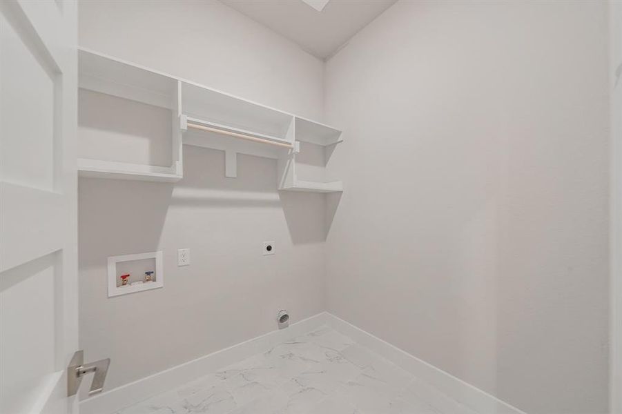Laundry area with electric dryer hookup, washer hookup, and light marble finish flooring