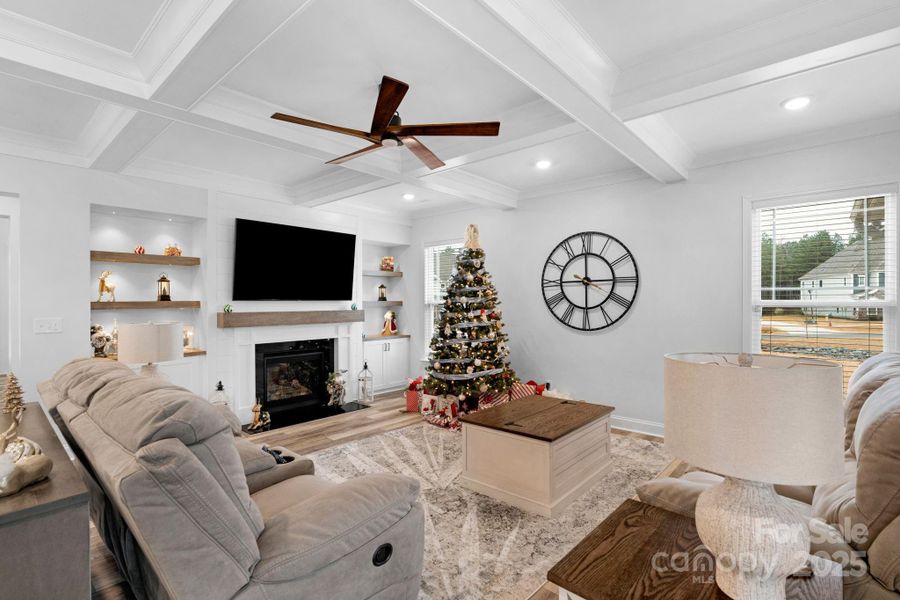 Beautiful family room with coffered ceiling, gas fireplace & built-in shelving