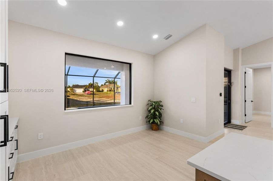 DINING ROOM features bright, modern design, neutral tones & vaulted ceiling w/ recessed lighting that enhances the open feel. LARGE PICTURE WINDOW brings in natural light & offers views of screened lanai & backyard.