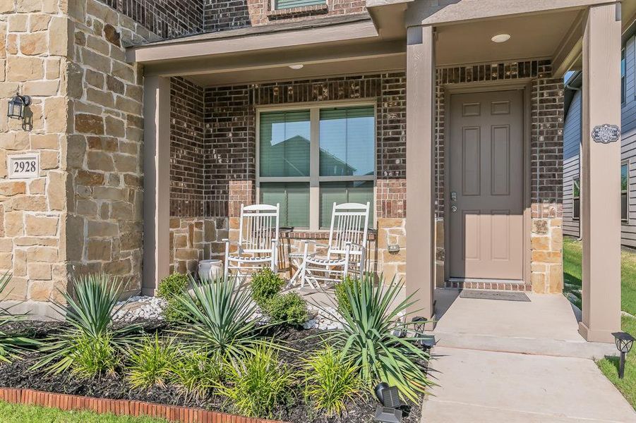 Doorway to property with brick siding and covered porch