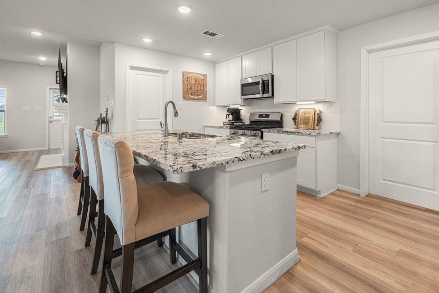 The granite counter tops with brushed nickel faucet enhances the contemporary feel to the bright and functional kitchen. The door to the right goes straight to the utility room then garage. The other door is to the oversized walk-in pantry! The granite counter tops with brushed nickel faucet enhances the contemporary feel to the bright and functional kitchen. The door to the right goes straight to the utility room then garage. The other door is to the oversized walk-in pantry!