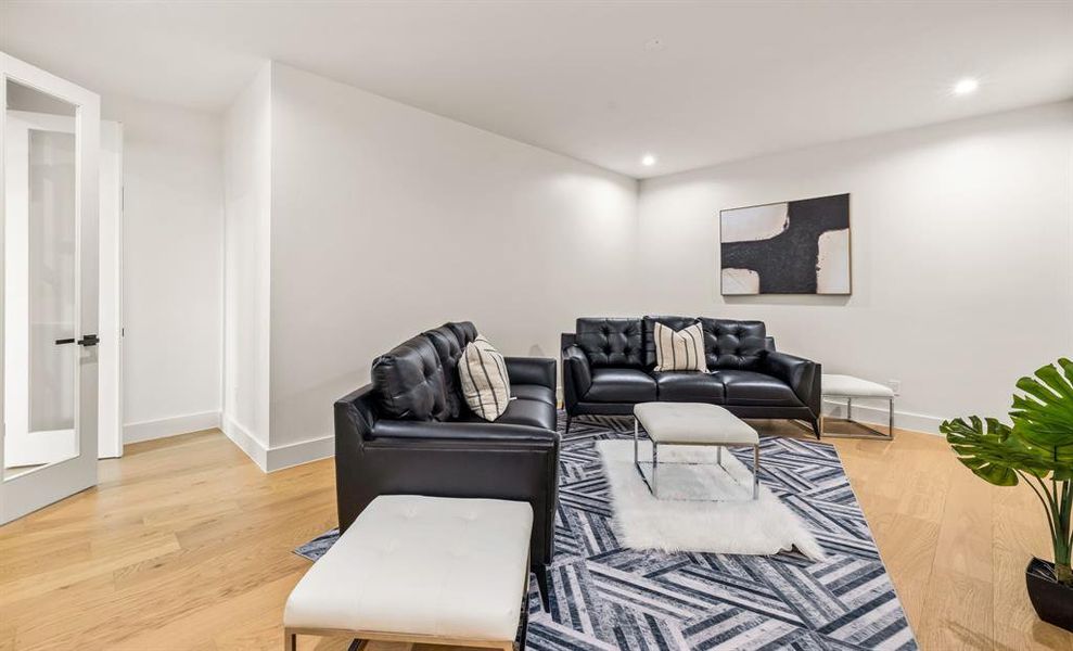 Living room featuring light wood finished floors and recessed lighting Living room featuring light wood finished floors and recessed lighting