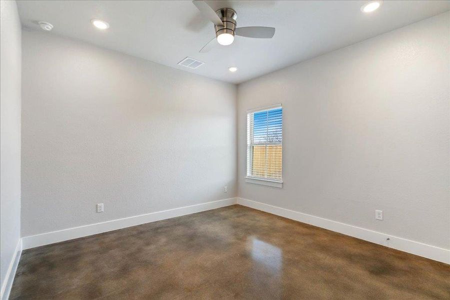High ceilings, a ceiling fan, and concrete flooring throughout this bedroom. High ceilings, a ceiling fan, and concrete flooring throughout this bedroom.