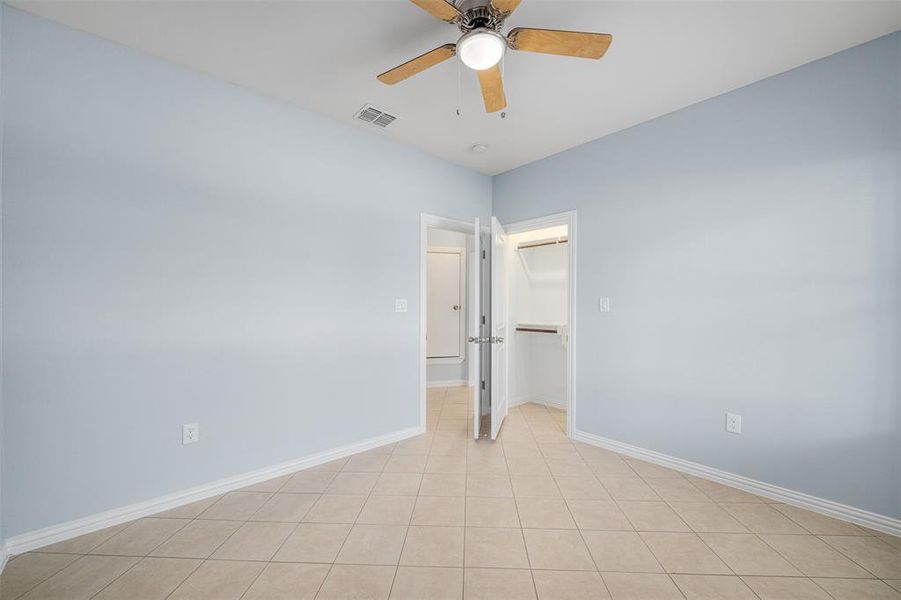 Tiled empty room with ceiling fan