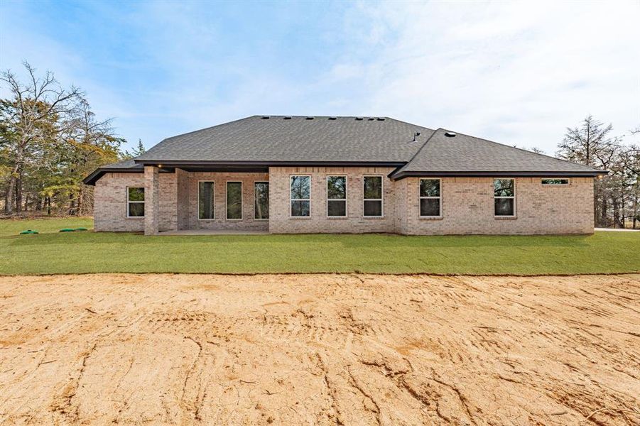 Back of house featuring brick siding, a patio, a yard, and roof with shingles Back of house featuring brick siding, a patio, a yard, and roof with shingles