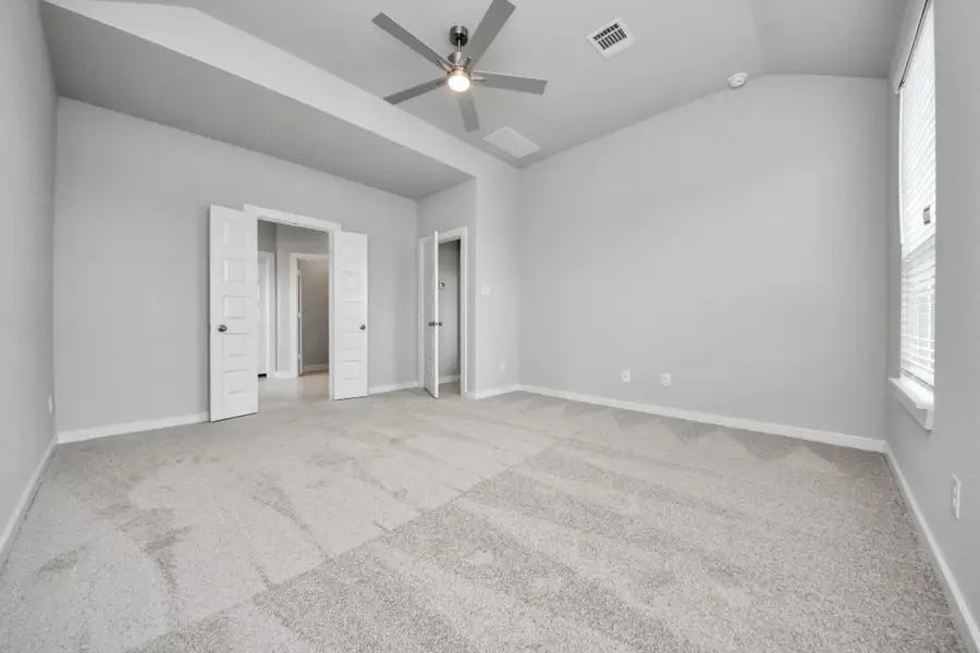 Come and unwind after a long day in this magnificent primary suite! This spacious room features plush carpet, warm paint, high ceilings and large windows with privacy blinds. Sample photo of completed home with similar floor plan. Actual colors and selections may vary.