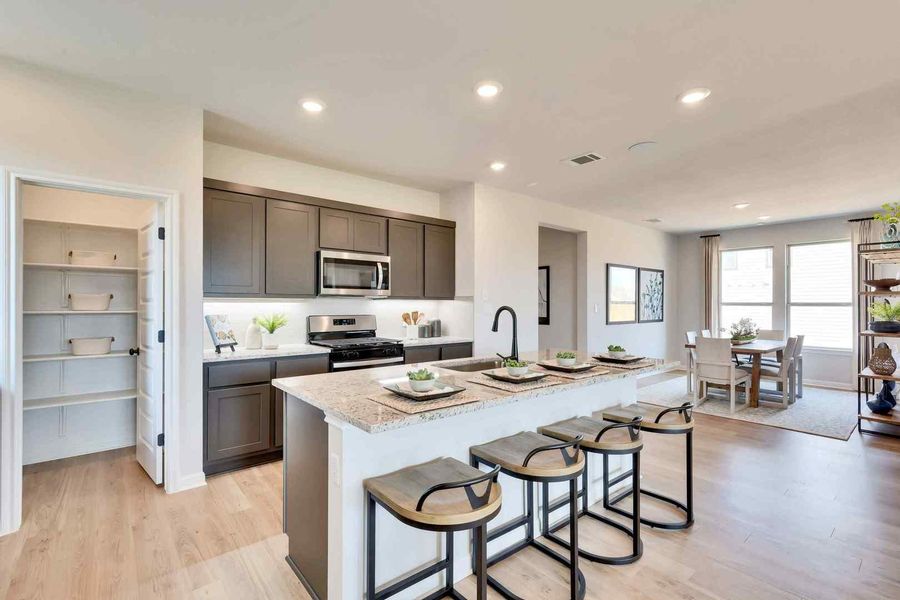 A well-appointed kitchen island with casual seating overlooks the combined dining space, creating an inviting atmosphere. A well-appointed kitchen island with casual seating overlooks the combined dining space, creating an inviting atmosphere.