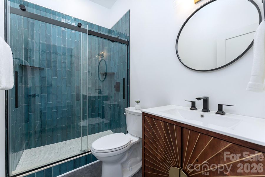 lower level full bathroom with tiled shower and glass doors
