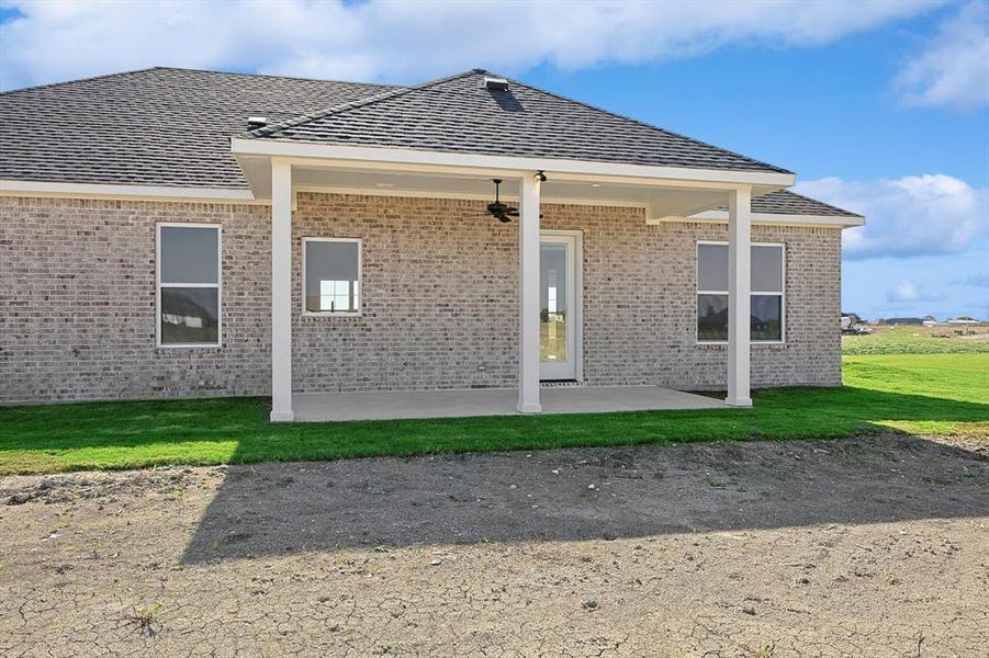 Back of house featuring a patio area and a lawn