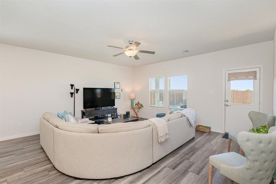 Living room with ceiling fan and light hardwood / wood-style flooring