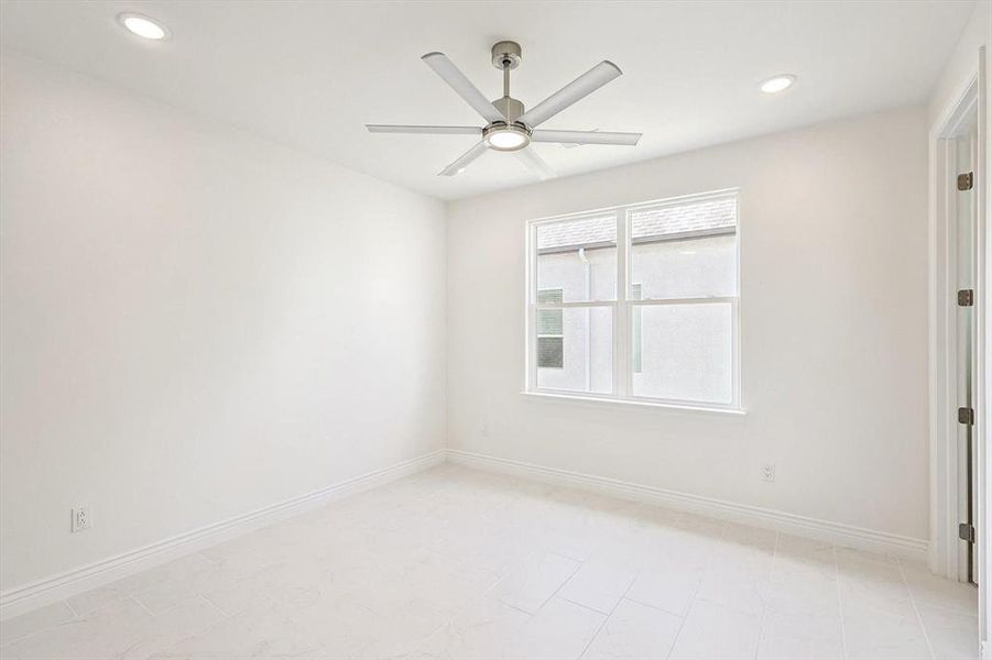 Spare room with ceiling fan and light tile floors