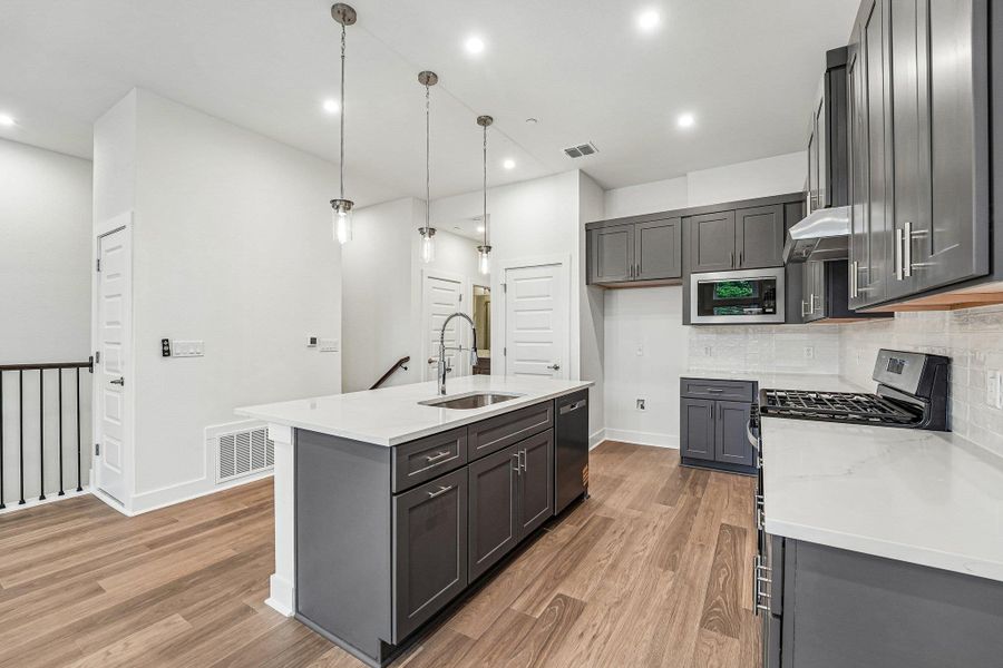 This stunning kitchen features,quartz counters, SS appliancesthat include a gas range and apantry. This stunning kitchen features,quartz counters, SS appliancesthat include a gas range and apantry.