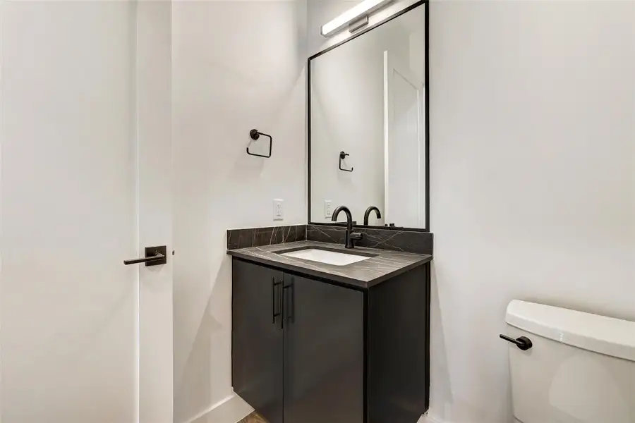 Half bath featuring vanity, toilet, and baseboards