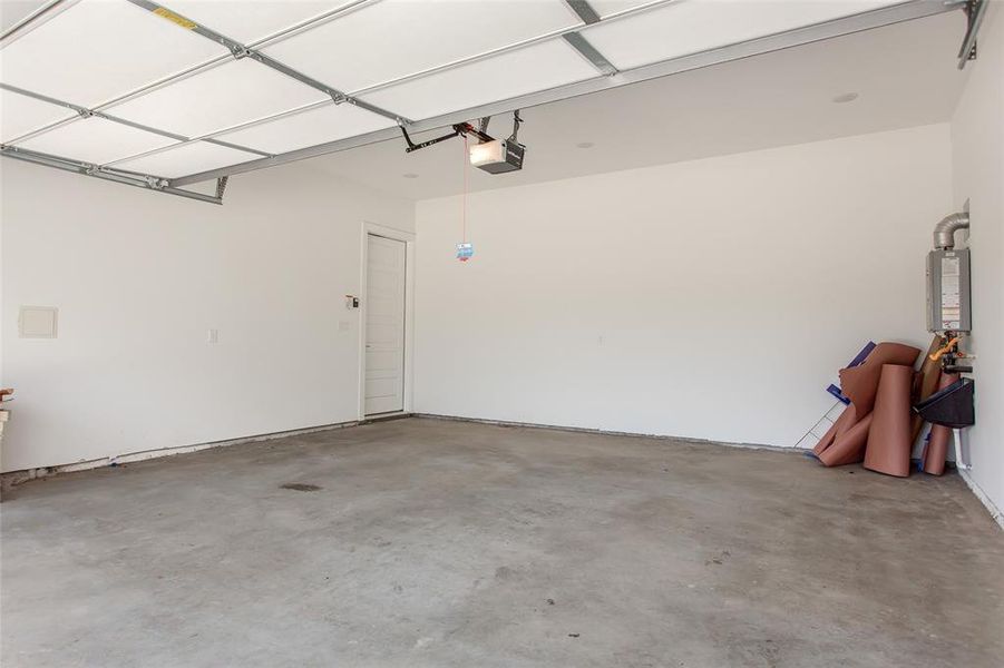 Garage featuring a garage door opener and water heater