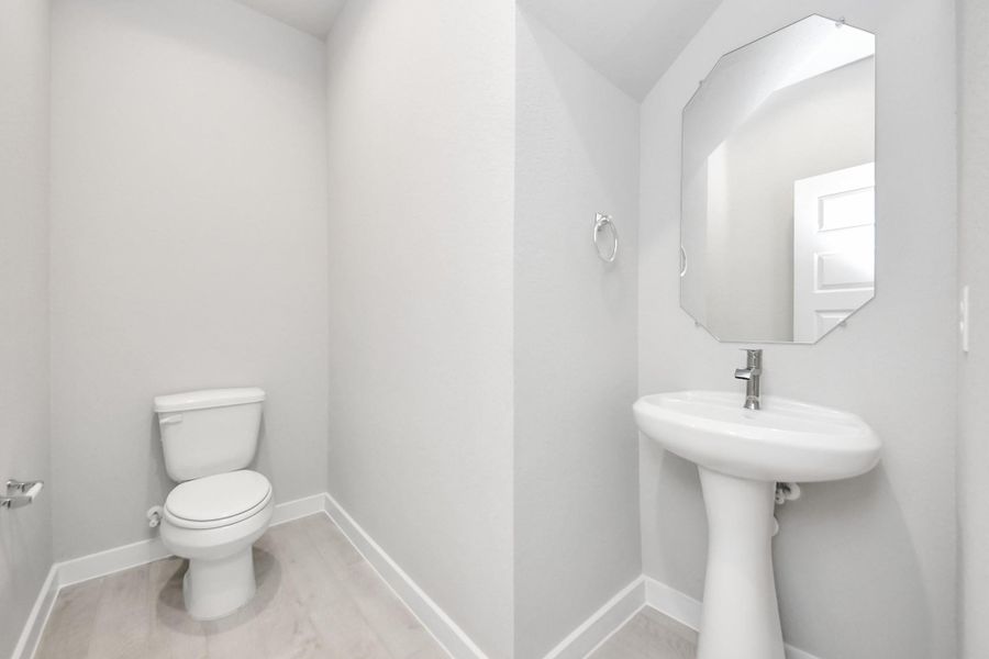 This half bathroom features a stylish pedestal sink, modern hardware, and bright recessed lighting, creating a sleek and inviting space. This half bathroom features a stylish pedestal sink, modern hardware, and bright recessed lighting, creating a sleek and inviting space.